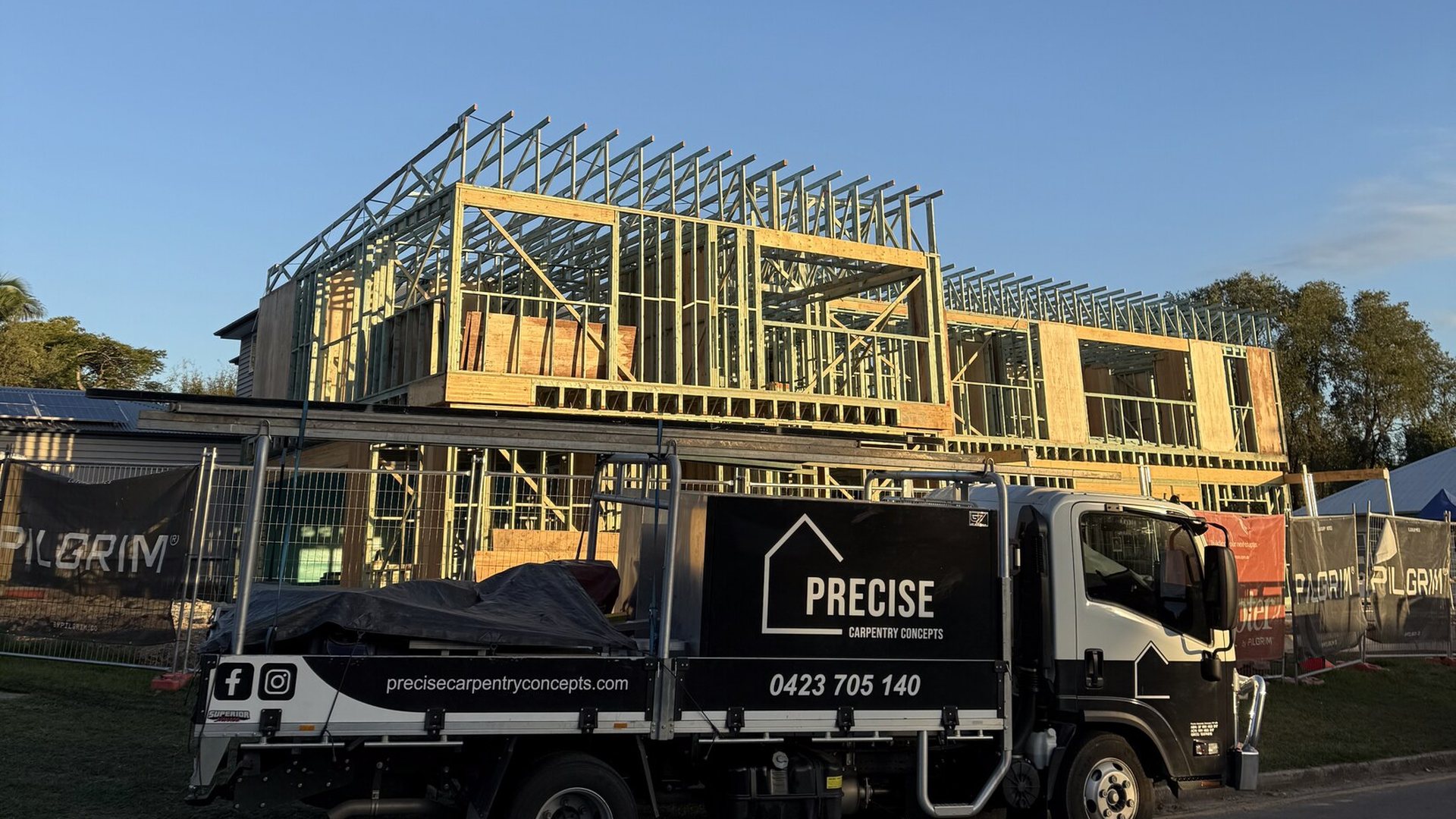 The Precise Carpentry Concepts truck parked in front of a two-storey timber frame